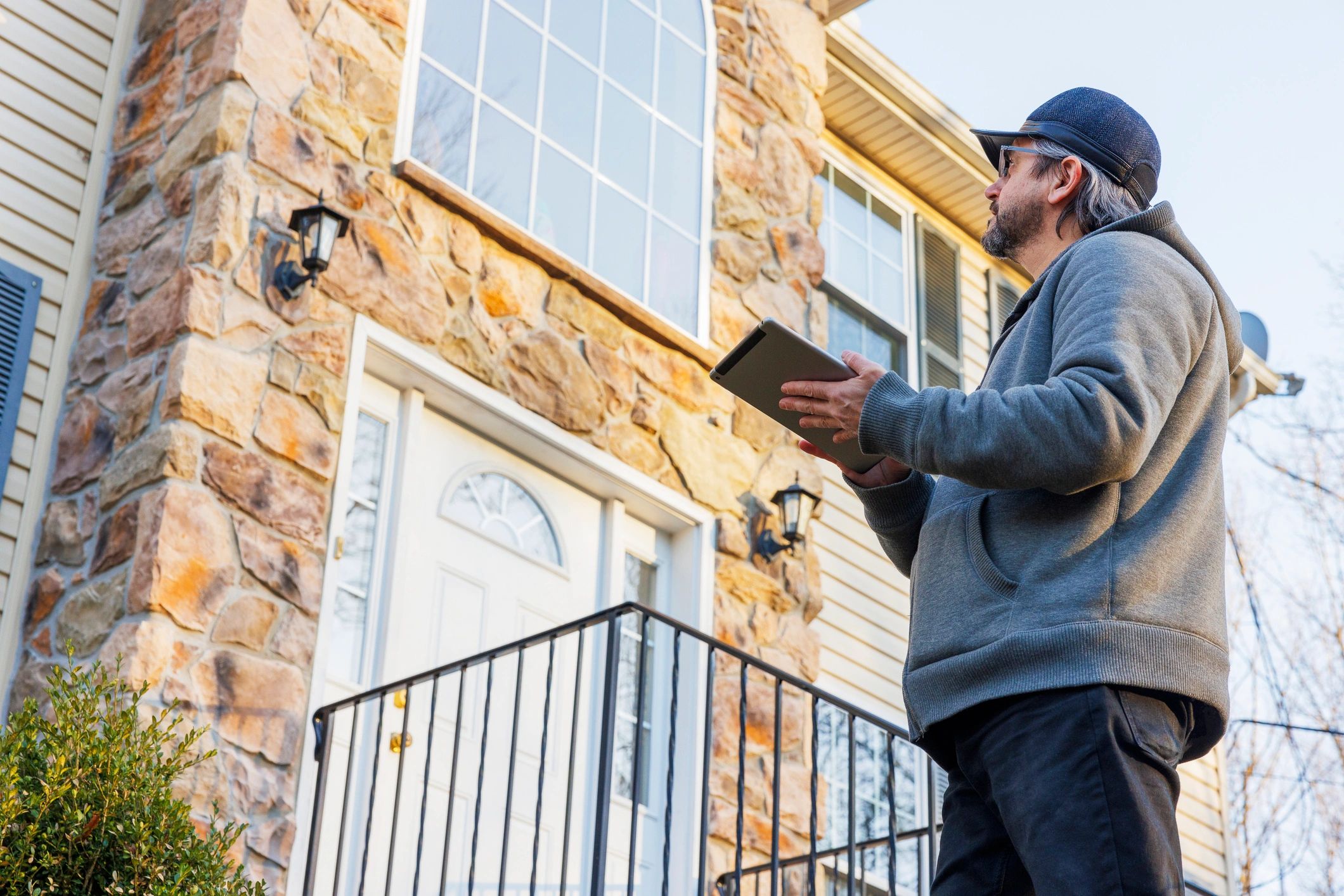Pest control technician inspecting a home's exterior